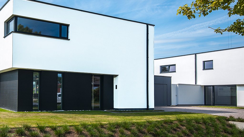 Moderne woning met witte gevelafwerking en zwart schrijnwerk